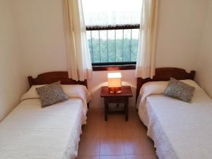 カンブリルスにあるMiramar Serveis - Villa Pamplonicaの窓とテーブル付きの部屋のベッド2台