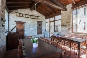 una sala da pranzo con un grande tavolo in legno e sedie di Agriturismo Le Querciole a Borgo Val di Taro