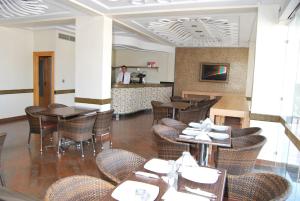 a restaurant with tables and chairs and a chef in the kitchen at Rofaida Appart'Hotel in Agadir