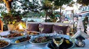 a table with plates of food and glasses of wine at Villa Bettina in Olympiada