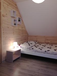 a small bedroom with a bed and a table at Domki Letniskowe Gris in Grzybowo