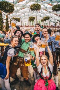 een groep mensen die een glas bier omhoog houden bij Festanation Oktoberfest Camp #2 in München