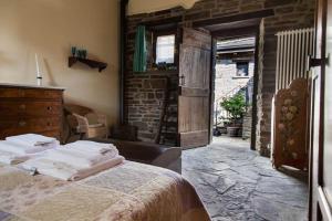 a bedroom with a bed and a brick wall at Agriturismo Le Querciole in Borgo Val di Taro