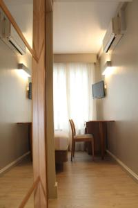 a room with a bed and a desk and a window at Hotel Carreño in Oviedo