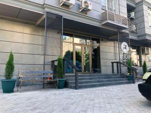 a building with a bench in front of it at Bugu Hotel Bishkek in Bishkek