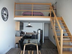 Cette chambre comprend une mezzanine avec une table en verre. dans l'établissement Bel appartement vue sur mer, à Cancale