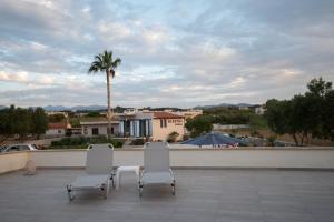 two white chairs sitting on top of a patio at Electra Studios in Gerani Chanion