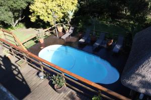a blue hot tub on a deck with potted plants at Allan Grove 2 in Knysna
