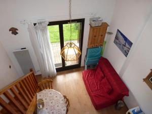 a living room with a red couch and a chair at JAUSIERS VILLAGE G 2 in Jausiers