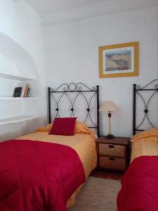 - une chambre avec 2 lits et des draps rouges dans l'établissement Tranquil Spanish Mountain Retreat, à Benirrama