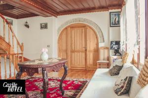 a living room with a table and a door at Castle Hotel in Gjirokastër
