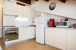 a kitchen with white cabinets and a white refrigerator at Casa Vacanze Un Tuffo Nel Blu in Matera