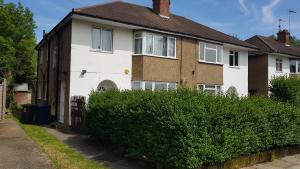 a house with a hedge in front of it at Elegant and spacious 2 bedroom in Barnet