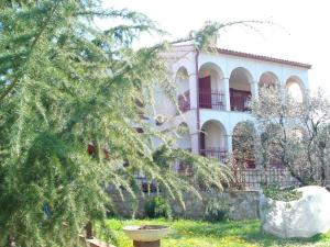 a large white building with a balcony and trees at Apartments Jelena in Peroj