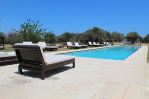 a pool with chaise lounge chairs and a swimming pool at Terre Di Vendicari in Noto