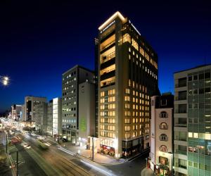 Un edificio alto en una calle de la ciudad por la noche. en Candeo Hotels Hiroshima Hatchobori, en Hiroshima