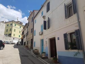 une ruelle étroite avec des bâtiments blancs dans une rue dans l'établissement Apartments Ivanis, à Vrsar