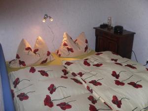 a bedroom with a bed with red flowers on it at Ferienwohnung Familie Rudolf in Coswig