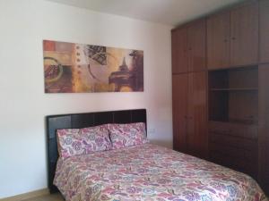ビトリア・ガステイスにあるApartamento céntricoのベッドルーム1室(ベッド1台付)が備わります。壁には絵画が飾られています。