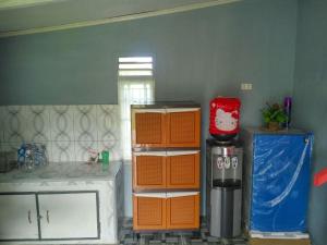 a kitchen with orange and white cabinets and a window at Pondok Oma in Lasikin