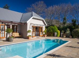 a swimming pool in front of a house at Summit Place Guesthouse in Cape Town