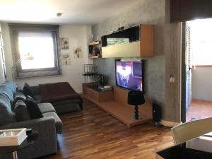een woonkamer met een bank en een flatscreen-tv bij SHG BLAU RESIDENCIAL III Wifi and Netflix in Cambrils