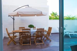 a table and chairs and an umbrella on a patio at Al Castello in Marsala