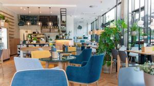 een restaurant met tafels en stoelen en een cafetaria bij McDreams Hotel Düsseldorf-City in Düsseldorf