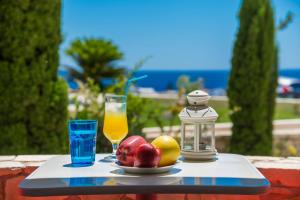a tray with fruit and a glass of orange juice at Caravella Luxury Apartments in Palaiochora