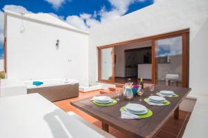 a wooden table with plates and wine glasses on a patio at Holiday house Casa Mariposa in Tabayesco in Tabayesco