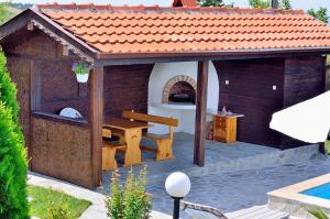 um pavilhão de madeira com uma mesa e um banco em Villa Knox em Bryastovets