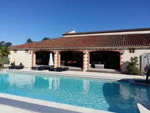a swimming pool in front of a house at La Minaudière in Nueil-sous-les-Aubiers