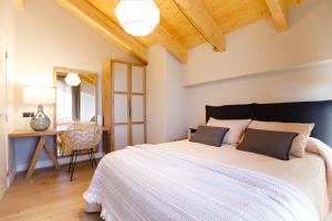 1 dormitorio con 1 cama blanca grande y escritorio en La Posada de Silvan, en Tella