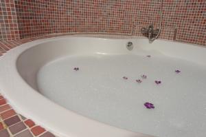 a bath tub filled with water with purple flowers in it at La Casa del Cubón in Aguilafuente