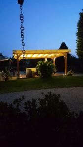 a wooden pergola in a yard with a bench at Agriturismo Loghino Caselle in San Giorgio Di Mantova