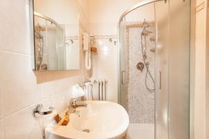 a white bathroom with a sink and a shower at Albergo Vittoria in Salsomaggiore Terme +17 photos