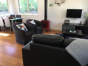 a living room with a couch and chairs and a stove at Haven Retreat in Berry