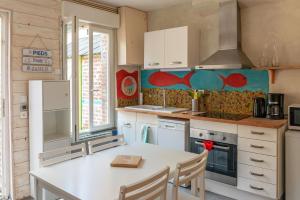 uma cozinha com uma mesa e um balcão branco em L'étoile de mer em Étretat