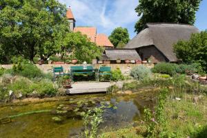 un jardín con mesa y sillas junto a un estanque en Haus Rosengarten, en Middelhagen