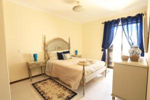 カルヴォエイロにあるCasa da Luaのベッドルーム1室(青いカーテン付きのベッド1台付)