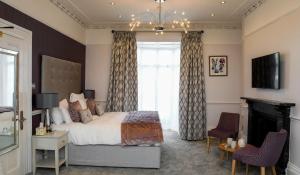 a bedroom with a large bed and a fireplace at Queens Court Hotel in Exeter