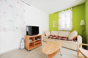 a living room with a couch and a tv at Olea Apartments in Srima