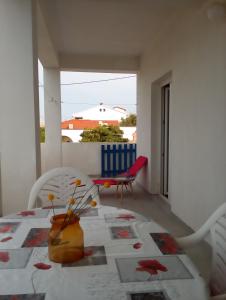 a white room with a table and chairs and a window at Apartments Boki in Pag