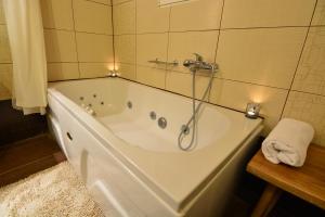 a bath tub with a shower in a bathroom at Green Village in Xylokastro +62 photos