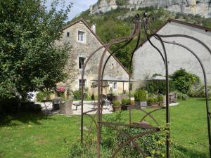 a garden in front of a stone house at La Grange à Nicolas in Baume-les-Messieurs