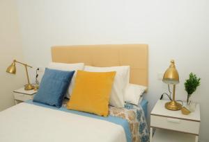 1 dormitorio con 1 cama con almohadas coloridas en Apartamento 2 dormitorios muy centrico, en Jerez de la Frontera