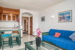 阿爾布費拉的住宿－Akisol Albufeira Quiet，一间带蓝色沙发的客厅和一间厨房