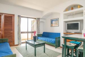 阿爾布費拉的住宿－Akisol Albufeira Quiet，客厅配有蓝色的沙发和电视