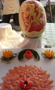 a melon with a flower painted on it next to some food at Agios Gordios Stevens on the hill in Agios Gordios