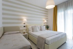 a bedroom with a white bed and a window at Hotel De Londres in Riccione